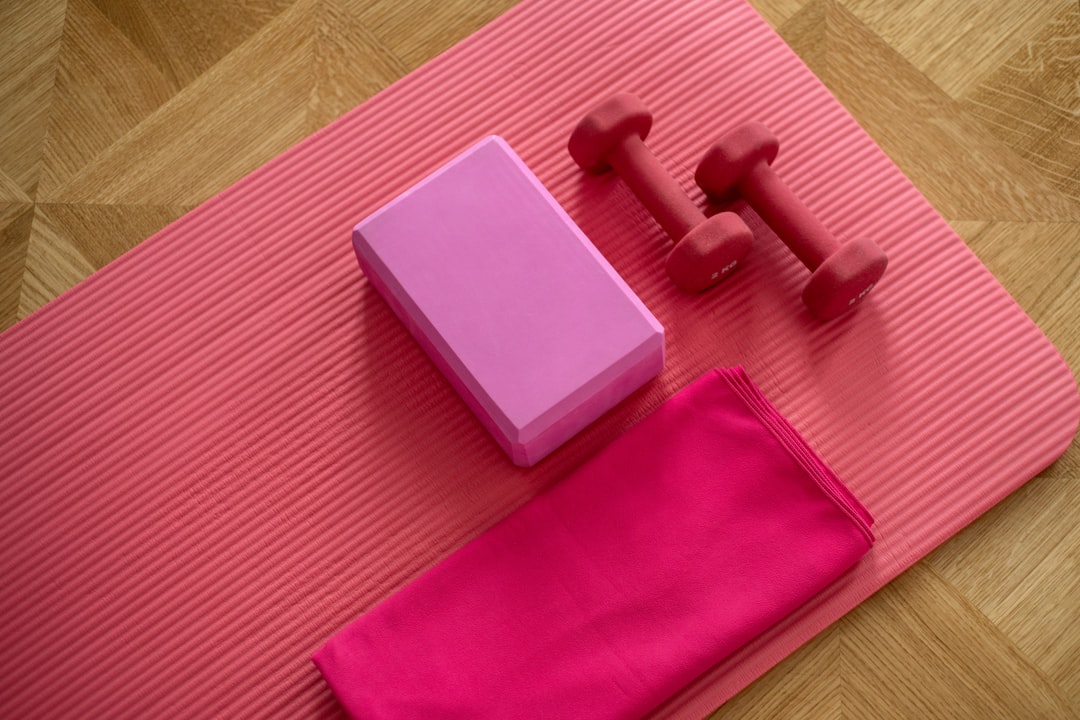 A collection of beginner-friendly fitness accessories like yoga mats, resistance bands, and dumbbells arranged in a cozy home setting.