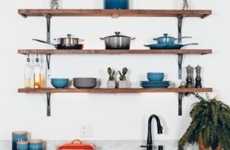 A well-organized small kitchen with creative storage solutions, showcasing vertical shelves, multi-use items, and a clutter-free countertop.
