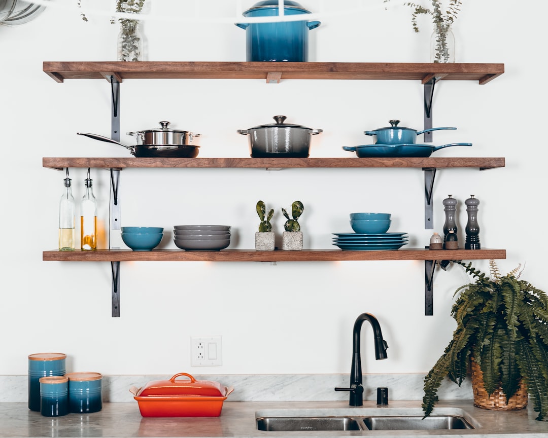 A well-organized small kitchen with creative storage solutions, showcasing vertical shelves, multi-use items, and a clutter-free countertop.