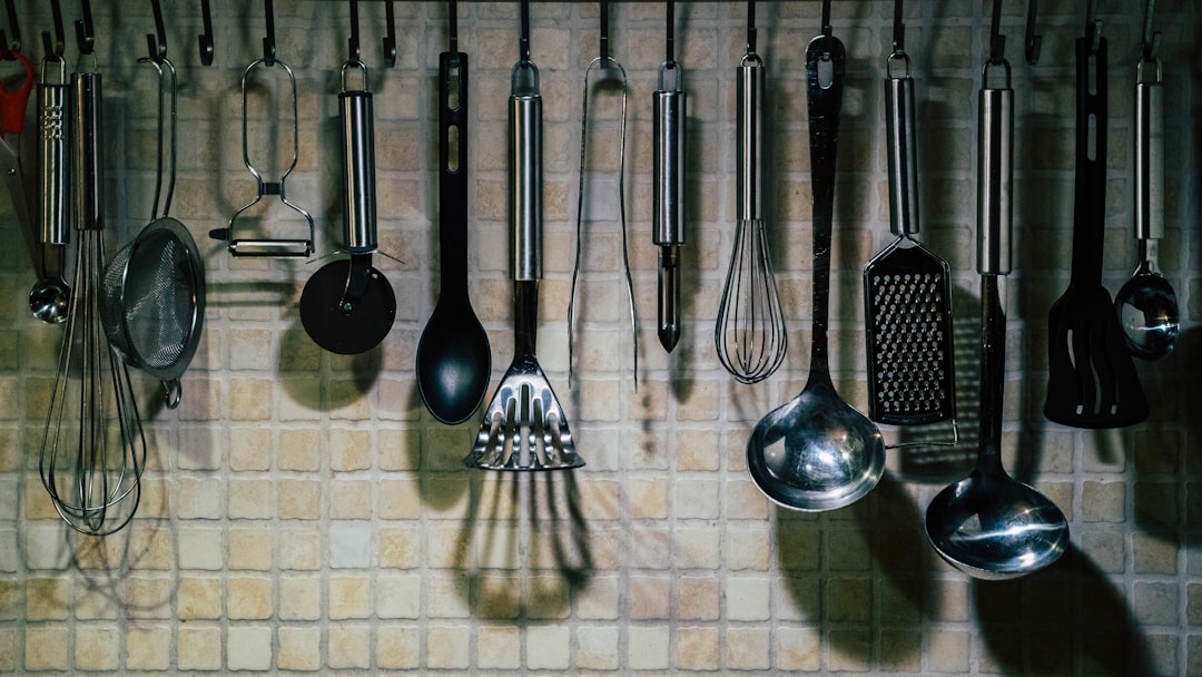 A collection of modern kitchen tools and gadgets on a countertop, showcasing items like a vegetable chopper, measuring cups, and a timer.