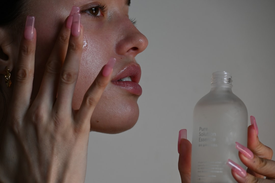 A serene image of a woman applying moisturizer to her face in a bright, natural setting, symbolizing simple skin care treatments.