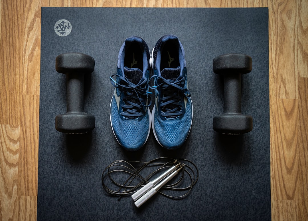 A collection of comfortable and practical workout gear laid out on a gym floor, including yoga mats, water bottles, and resistance bands.